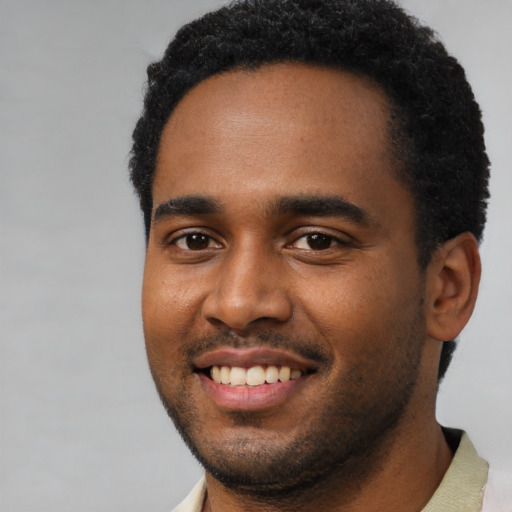 Joyful black young-adult male with short  black hair and brown eyes