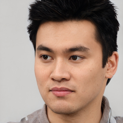 Joyful asian young-adult male with short  black hair and brown eyes