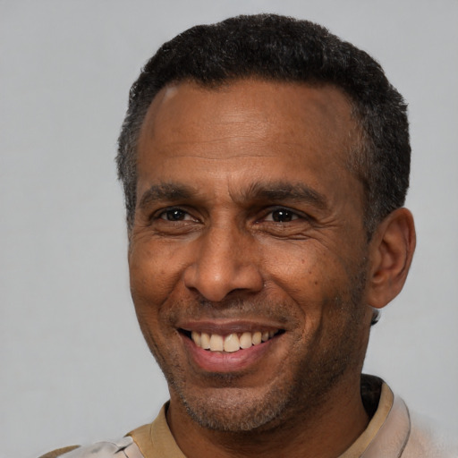 Joyful latino adult male with short  black hair and brown eyes