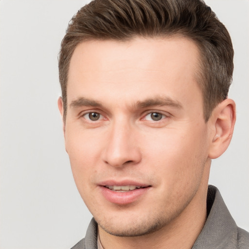 Joyful white young-adult male with short  brown hair and grey eyes