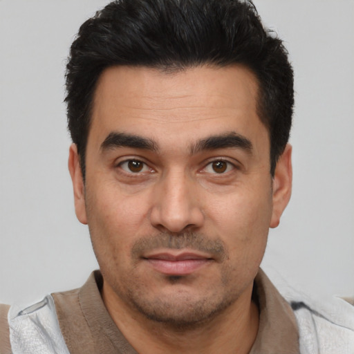 Joyful latino young-adult male with short  black hair and brown eyes