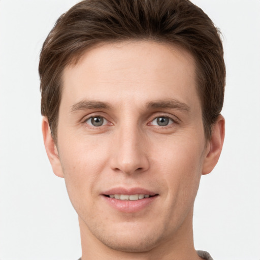 Joyful white young-adult male with short  brown hair and grey eyes