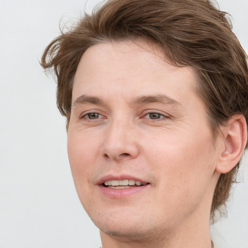 Joyful white young-adult male with medium  brown hair and grey eyes