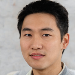 Joyful asian young-adult male with short  black hair and brown eyes