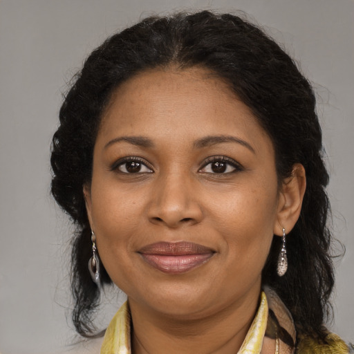 Joyful black adult female with long  brown hair and brown eyes