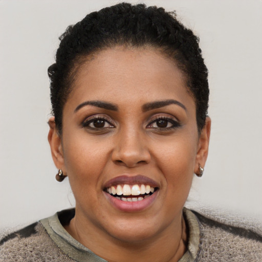 Joyful black young-adult female with short  brown hair and brown eyes