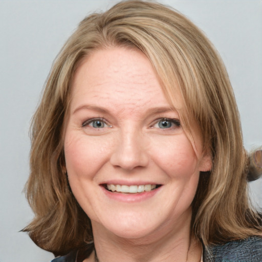 Joyful white adult female with medium  brown hair and blue eyes