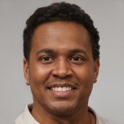Joyful latino young-adult male with short  brown hair and brown eyes