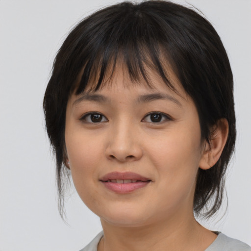 Joyful asian young-adult female with medium  brown hair and brown eyes