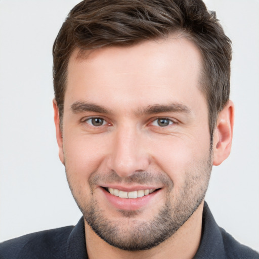 Joyful white young-adult male with short  brown hair and grey eyes