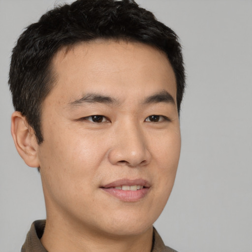 Joyful asian young-adult male with short  black hair and brown eyes