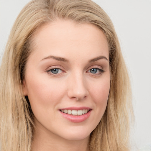 Joyful white young-adult female with long  brown hair and blue eyes