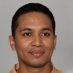 Joyful latino young-adult male with short  brown hair and brown eyes