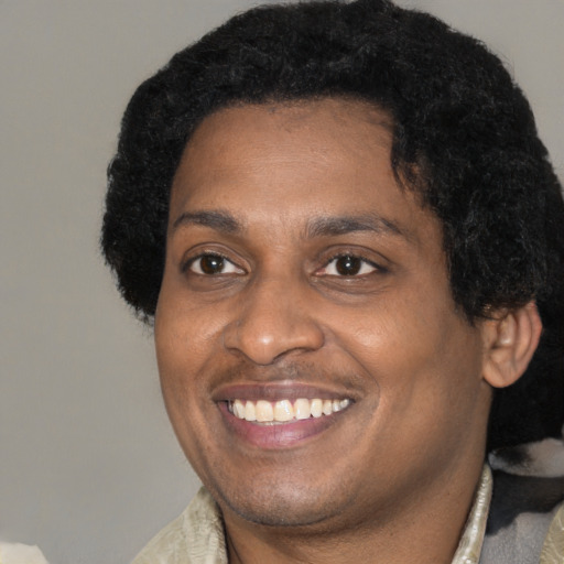 Joyful black adult male with short  brown hair and brown eyes
