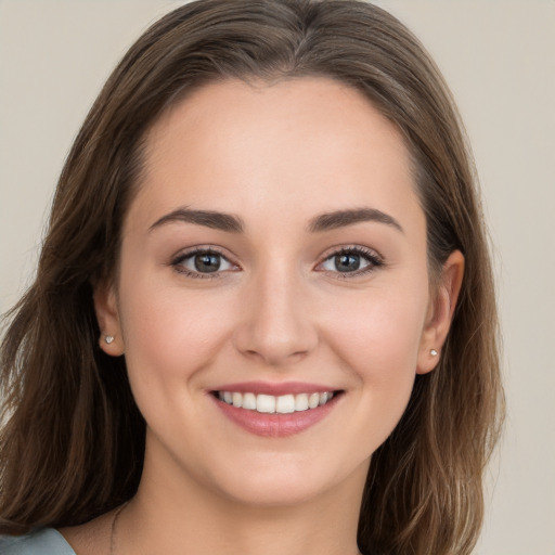 Joyful white young-adult female with long  brown hair and grey eyes