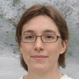 Joyful white adult female with medium  brown hair and green eyes