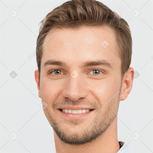 Joyful white young-adult male with short  brown hair and grey eyes