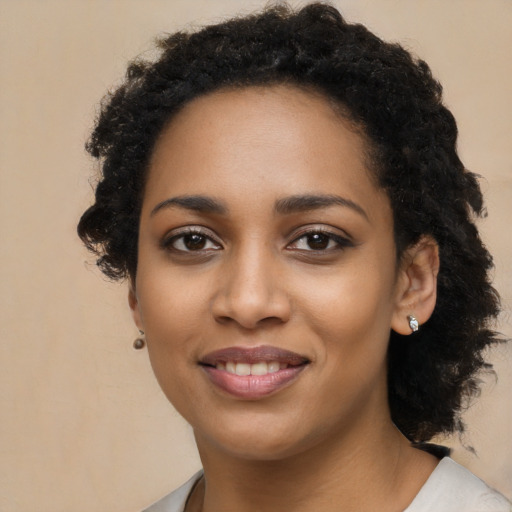 Joyful black young-adult female with long  black hair and brown eyes