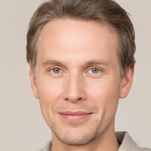 Joyful white adult male with short  brown hair and grey eyes