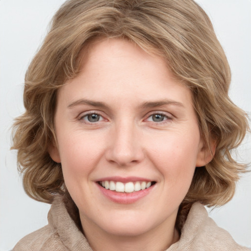 Joyful white young-adult female with medium  brown hair and blue eyes