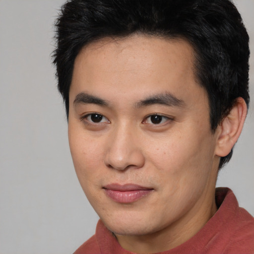 Joyful asian young-adult male with short  black hair and brown eyes