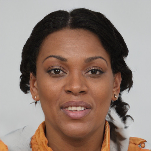 Joyful black adult female with medium  brown hair and brown eyes
