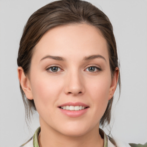 Joyful white young-adult female with medium  brown hair and grey eyes