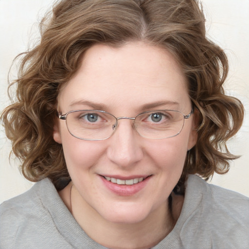 Joyful white adult female with medium  brown hair and blue eyes