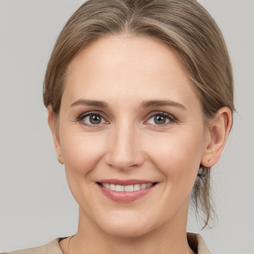 Joyful white young-adult female with medium  brown hair and grey eyes