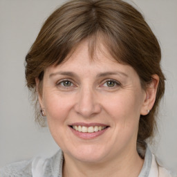 Joyful white adult female with medium  brown hair and grey eyes