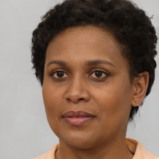 Joyful black adult female with short  brown hair and brown eyes