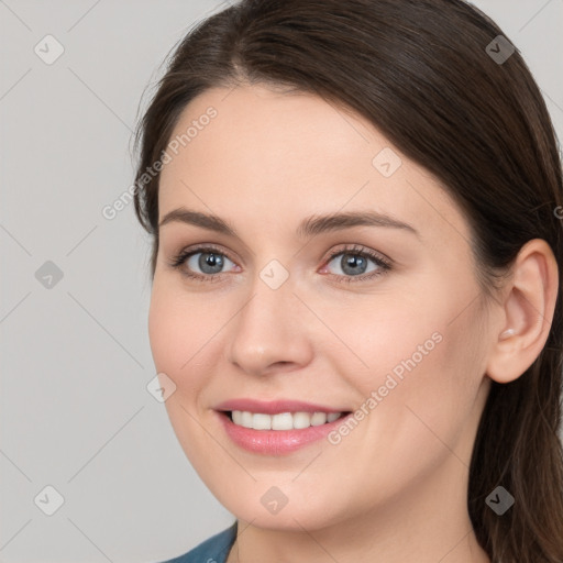 Joyful white young-adult female with long  brown hair and grey eyes