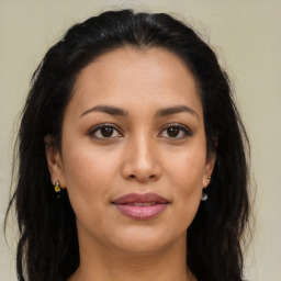 Joyful latino young-adult female with long  brown hair and brown eyes