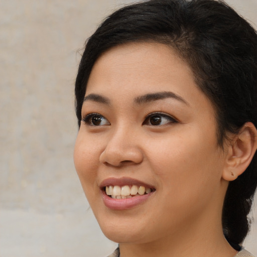 Joyful latino young-adult female with medium  brown hair and brown eyes
