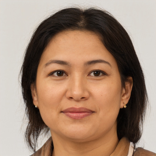 Joyful asian adult female with medium  brown hair and brown eyes