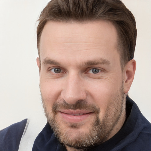 Joyful white adult male with short  brown hair and grey eyes