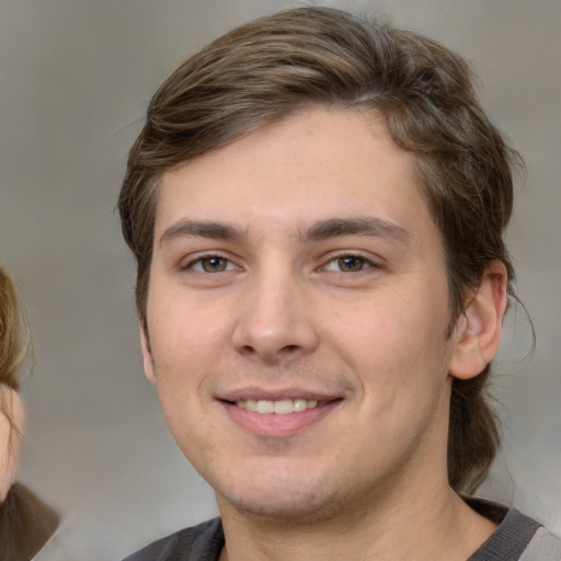 Joyful white young-adult male with medium  brown hair and grey eyes