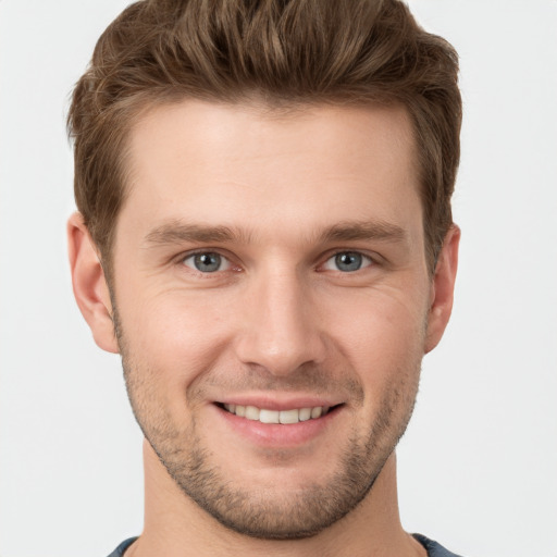 Joyful white young-adult male with short  brown hair and grey eyes