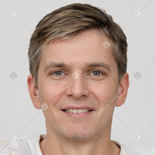 Joyful white young-adult male with short  brown hair and grey eyes