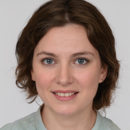 Joyful white young-adult female with medium  brown hair and blue eyes