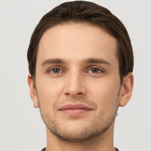 Joyful white young-adult male with short  brown hair and grey eyes