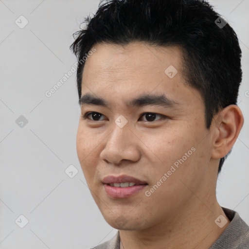Joyful asian young-adult male with short  black hair and brown eyes