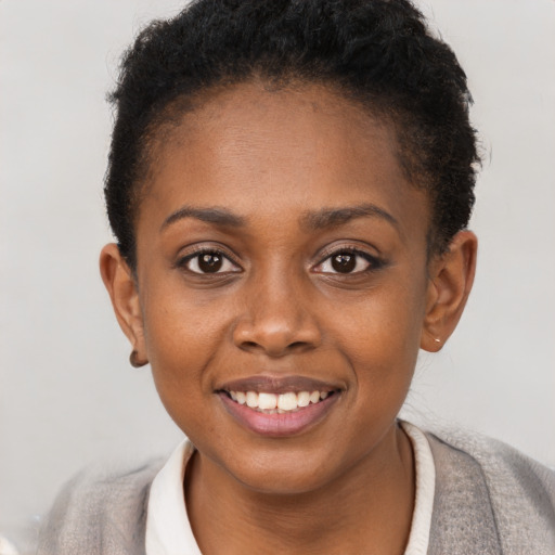 Joyful black young-adult female with short  brown hair and brown eyes