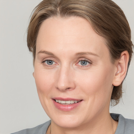 Joyful white adult female with medium  brown hair and grey eyes