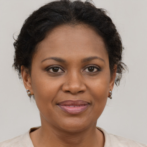 Joyful black adult female with short  brown hair and brown eyes