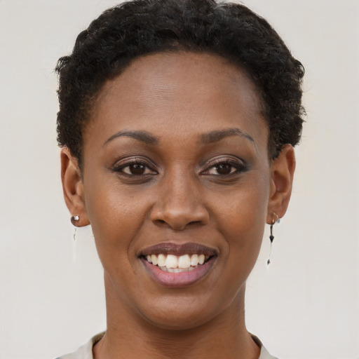 Joyful black young-adult female with short  brown hair and brown eyes