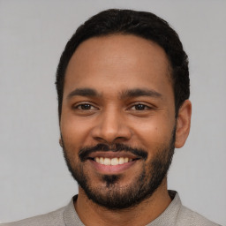 Joyful latino young-adult male with short  black hair and brown eyes