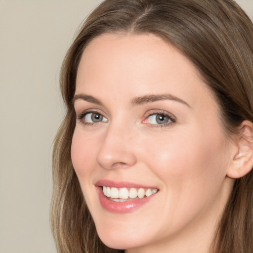 Joyful white young-adult female with long  brown hair and green eyes