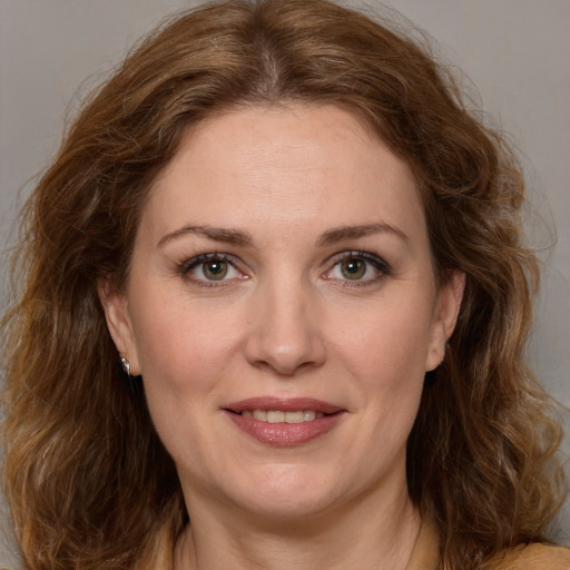 Joyful white adult female with medium  brown hair and green eyes