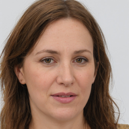 Joyful white adult female with long  brown hair and green eyes